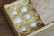 Several chicken white eggs in a wooden box.