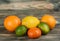 Several citrus fruits: oranges, tangerines, lemon and limes on a wooden table