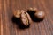 Several coffee beans on a wooden burnt background. Macro