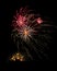 Several colorful fireworks exploding in the dark sky in the middle of the night. The explosions light the sky creating colorful