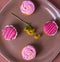 Several colorfully decorated cupcakes on a brown plate, top view