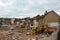 Several construction excavators are engaged in dismantling an old house. Dismantling the city\\\'s housing stock for renovation