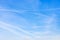 Several contrails and cirrus clouds in blue sky