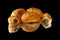 Several croissants on mirrored surface with reflection. One croissant is cut in half. Isolated on black background