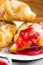 Several croissants smeared with strawberry jam