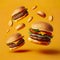 Several Delicious fast food hamburgers flying on a yellow background.