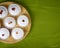 Several and Delicious Raw French dessert Meringues with Strawberry sauce on a green tablecloth and a round wooden plate. Top view