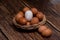 Several eggs lay in a basket on a wooden floor.
