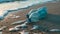 Several empty plastic water bottles discarded on a sandy beach.