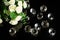 Several excellent pure diamonds and bouquet of white roses with reflection on black mirror background close up view. Jewelry