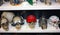 Several fake plastic skulls disguised with cute and funny accessories arranged on a shelf lined up for sale