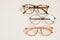 Several fashionable stylish glasses on a beige background place copy top view, optics store
