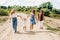 Several generations of women of the same family are walking along a dirt road outside the city, enjoying the time spent