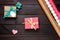 Several gift boxes, wrapping paper and paper hearts on a dark wooden table. Festive, romantic Flat Lay