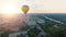 Several hot air balloons floating over city toward rising sun over horizon, hope