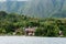 Several houses build at the foot of a mountain next to a lake in Sumatra Samosir Island.