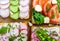 Several kinds of sandwiches with vegetables: radish, tomatoes, cucumber, arugula on crispy toast