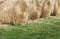 Several large round hay bales on grass.