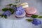 Several macaroons lie on the table decorated with flowers.