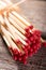 Several matchsticks with red heads bonded by straw