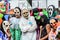 several men and one woman wearing colorful masks and costumes while standing in front of an