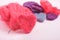 Several multi-colored felted woolen hearts on pink background