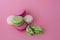 Several multi-colored macarons on a pink background