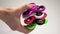 Several multi-colored spinners in hand.