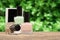 Several nail polish bottles in spring garden. Set of nail polish bottles on wooden desk on green leaves background