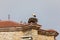 Several pairs of storks and nests on the roof of a church