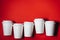 Several paper cups on red background