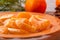 Several peeled tangerine slices on an orange plate with tree branches and a cone-a traditional Christmas and new year`s