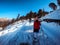 several people in red jackets are walking on snow covered trail