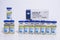 Several Pfizer vials vaccine bottles of covid-19 immunization with package box and an