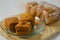 Several pieces of brown tofu or tahu pong in plastic and three tofus in small plate