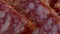 Several pieces of sausage close-up. Salami, full frame. Full hd video, selective focus. Slicing the sausage. Raw smoked sausage