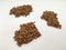 Several piles of buckwheat kernels on a white background close.