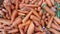 several piles of carrots for sale in the market