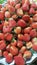 several piles of strawberries for sale in the market