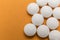Several pills white aligned isolated on the orange background