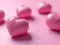 several pink heart shaped objects on pink background