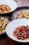 Several plates of pasta with different kinds of sauce over wooden background, top view.
