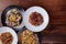 Several plates of pasta with different kinds of sauce over wooden background, top view.