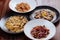 Several plates of pasta with different kinds of sauce over wooden background, top view.
