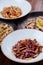 Several plates of pasta with different kinds of sauce over wooden background, top view.