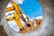 Several powerful excavators at the construction site. View of the excavator through the pipe. Close-up of earthmoving machinery.