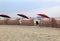 Several red and white striped cabanas on the sandy shores of beach