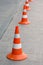 Several road cones on a square gray tile.