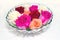 Several rose blossoms in retro glass bowl