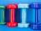 Several sports dumbbells of different colors on the fitness Mat